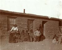 Thumbnail for 'Group Portrait: Indian Men and Women Sitting Outside a Dwelling'