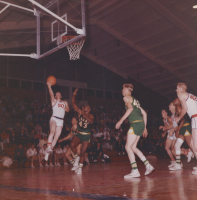 Thumbnail for 'A Mountaineer player goes up for a layup against Adams State College in Mountaineer Gymnasium, 1963.'