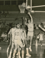 Thumbnail for 'A Mountaineer attempts a shot under the basket in Wright Gymnasium, ca. 1984.'