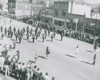 Thumbnail for 'Saguache High School marching band makes its way up Main Street in the 1956 WSC Band Day parade.'