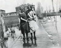 Thumbnail for 'Two coeds stand in the Spring runoff southwest of Taylor Hall, circa 1920.'