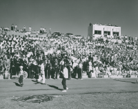 Thumbnail for 'Participating marching bands gather in the Mountain Bowl bleachers before performing at WSC's Band Day, ca. 1959.'