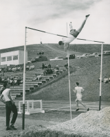 Thumbnail for 'A pole vaulter attempts to clear the bar in Mountaineer Bowl track and field competition, 1957.'