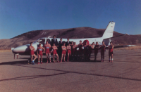 Thumbnail for 'The Mountaineer wrestling team poses for a team photograph in front of a chartered jet at Gunnison County airport, ca. 1989.'
