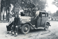 Thumbnail for 'Members of the Hiking and Outing Club pose on top of a 1930s Chevy, circa 1942.'