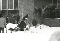 Thumbnail for 'A cross country ski competitor skis by spectators in front of the WSC Student Union, 1980s.'