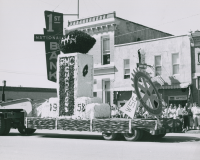 Thumbnail for 'A float sponsored by Rotary International moves up Main Street during WSC's 1958 Homecoming parade.'