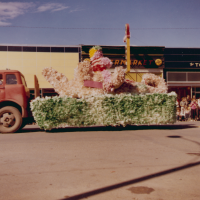 Thumbnail for 'A 1961 Homecoming float from an unknown organization travels south on Main Street.'