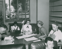 Thumbnail for 'A freshman coed registers for a class among a group of her peers and the instructor in Leslie J. Savage Library, circa 1954.'