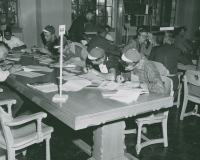 Thumbnail for 'A group of freshmen work on class registration forms in Leslie J. Savage Library'