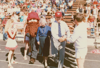 Thumbnail for 'The WSC Mountaineer mascot escorts two honored alumni to the Mountaineer Bowl field during halftime activites, 1987.'