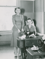 Thumbnail for 'Two Home Economics students pose for a photograph with their Singer sewing machines, circa 1950.'