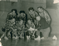 Thumbnail for 'Coach Paul Wright reviews some strategies with his basketball squad, ca. 1940.'